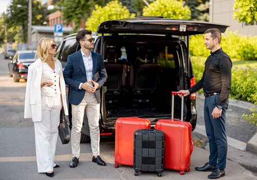 business-couple-near-minivan-taxi-with-suitcases-chauffeur-2