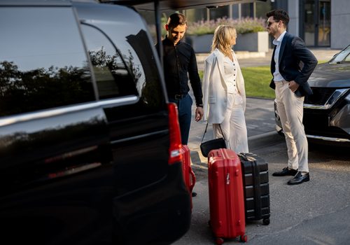 business-couple-near-minivan-taxi-with-suitcases-chauffeur