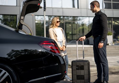 chauffeur-packs-suitcase-car-trunk-businesswoman-waiting-nearby-using-luxury-taxi-service-business-trip-concept-business-transfer-services-idea-personal-driver